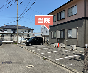 右手側に見えるマンションの１０１号室が当院です